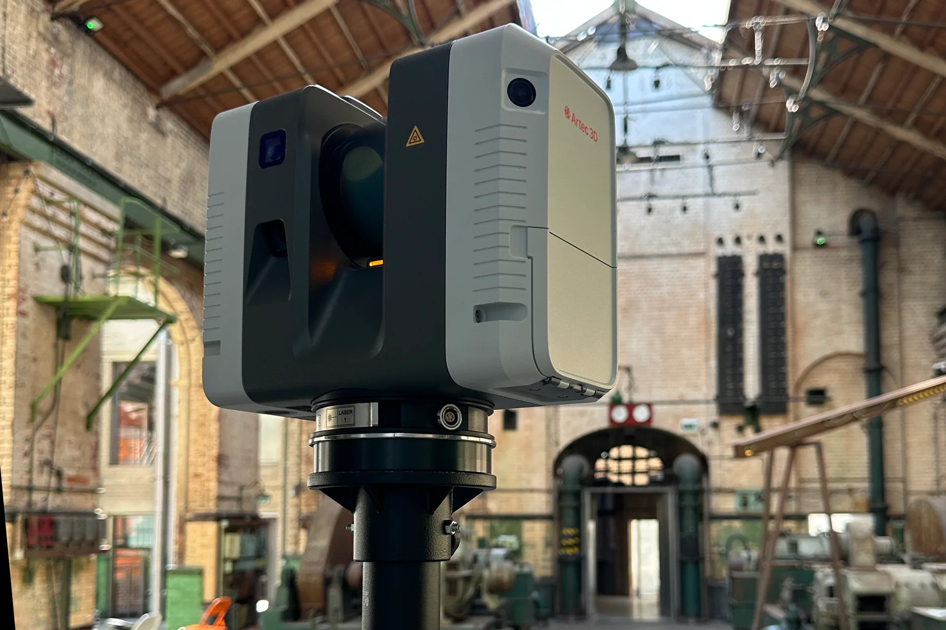 Artec Ray II laser scanner on a tripod inside a brick engine hall